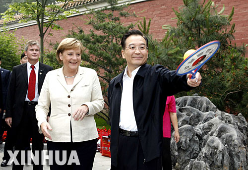 5月22日，國務院總理溫家寶陪同正在北京進行正式訪問的德國總理默克爾在北京菖蒲河公園散步。這是溫家寶在向默克爾介紹太極柔力球的玩法。 新華社記者 饒愛民 攝