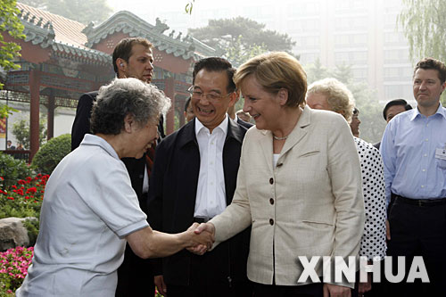 5月22日，國務院總理溫家寶陪同正在北京進行正式訪問的德國總理默克爾在北京菖蒲河公園散步。這是默克爾在公園裏和晨練的居民握手。 新華社記者 饒愛民 攝