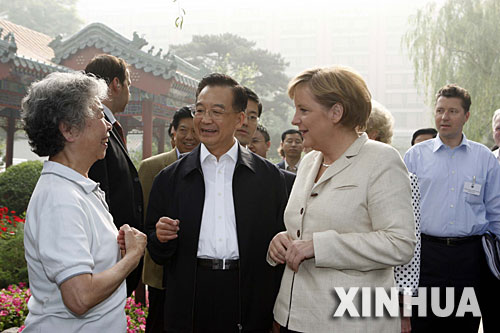 5月22日，國務院總理溫家寶陪同正在北京進行正式訪問的德國總理默克爾在北京菖蒲河公園散步。這是溫家寶、默克爾與在公園晨練的居民交談。 新華社記者 饒愛民 攝