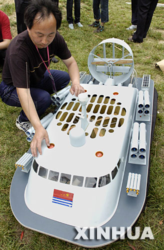 5月25日，天津隊選手在比賽前調試氣墊導彈艇模型。 在蘇州石湖風景區舉行的第三屆全國體育大會航海模型比賽中，參賽的航海模型各施絕技，吸引了衆多航模愛好者前來觀看。 新華社記者孫參攝 