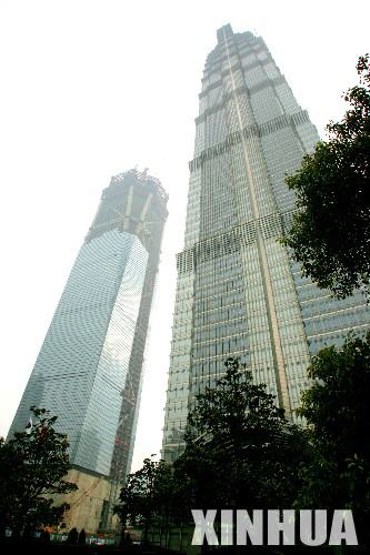 正在建設中的上海環球金融中心(左)已升至79層，高度達到340.1米(1月22日攝)。上海環球金融中心工程是一幢以辦公爲主，集商貿、賓館、觀光、展覽及其他公共設施於一體的大型超高層建築，位於浦東陸家嘴，與金茂大廈相距僅40米。工程總建築面積377300平方米，塔樓地上101層，地面以上高度爲492米。