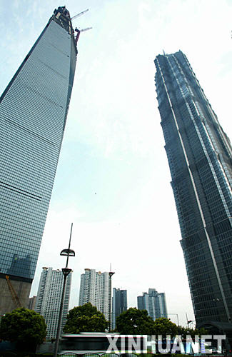 目前已建至97層的上海環球金融中心(左)(7月19日攝)。 近年來，隨着跨國企業駐滬機構的不斷增多，上海甲級寫字樓租售一直處於供不應求的態勢。即將封頂的101層頂級綜合大廈――上海環球金融中心目前已建至97層，建成後將成爲世界第一高樓，其租金也將成爲上海最高，未來租金定位在每平方米每天3.3美元。