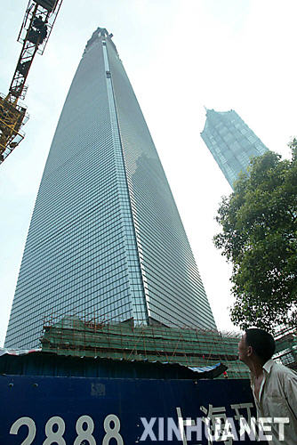 7月19日，一名工人正向在建的上海環球金融中心樓頂仰望。 近年來，隨着跨國企業駐滬機構的不斷增多，上海甲級寫字樓租售一直處於供不應求的態勢。即將封頂的101層頂級綜合大廈――上海環球金融中心目前已建至97層，建成後將成爲世界第一高樓，其租金也將成爲上海最高，未來租金定位在每平方米每天3.3美元。
