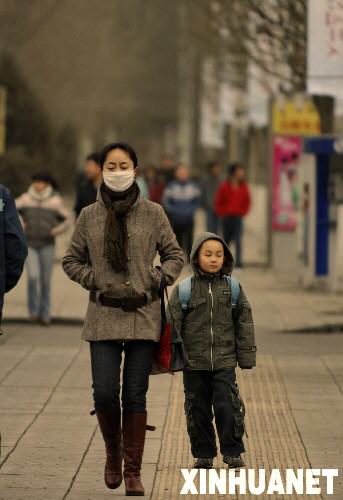 3月1日，一位呼和浩特市市民戴着口罩在街頭行走。內蒙古自治區氣象部門當日實時監測表明，內蒙古烏蘭察布市、呼和浩特市、巴彥淖爾市、烏海市以及阿拉善盟等地區出現程度不同的揚沙天氣，同時內蒙古中西部地區氣溫下降4至6度。 新華社記者李欣攝