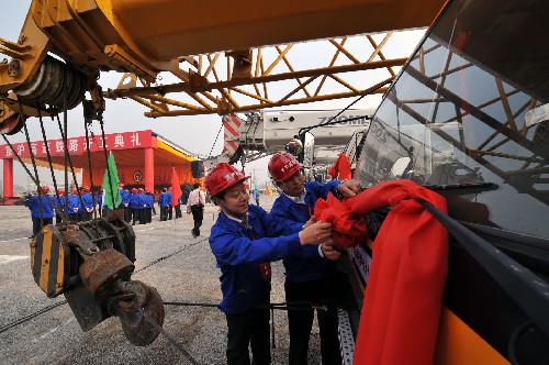 4月18日，參加京滬高速鐵路開工典禮的工人師傅在施工車上系大紅花。