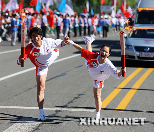 7月13日，火炬手徐铭（左）与火炬手方丹在交接后庆祝。当日，北京奥运圣火在黑龙江省齐齐哈尔市传递。 新华社记者邢广利摄 