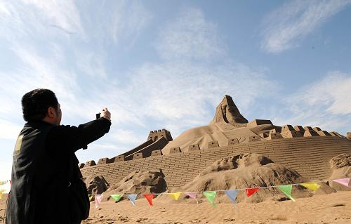 宁夏打造沙漠旅游品牌 一名游人在宁夏沙湖风景区内的一组沙雕作品前拍照(9月10日摄)。 三面环沙的宁夏,沙漠紧邻河流、湖泊、草原,旅游资源丰富,交通条件便利。加之,宁夏努力挖掘沙漠旅游文化、开拓游客喜闻乐见的项目。目前,沙漠旅游收入已超过1亿元。 新华社记者 刘泉龙摄