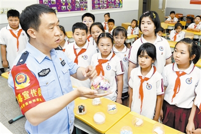 图为东丽团区委与区禁毒办在丽泽小学开展禁毒主题宣传,民警向学生们